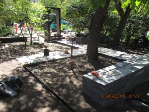 Bluestone random paving path flanked by stacked bluestone walls leads up to a feature doorway made of steel in spectacular Camberwell garden designed by Ian Barker Gardens