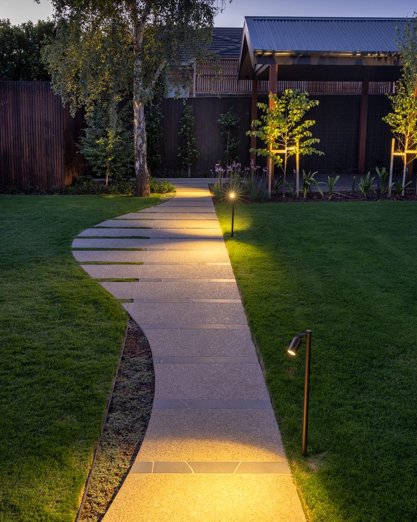 Path pole lights along a concrete path in a garden designed by Ian Barker Gardens in Hawthorn East.